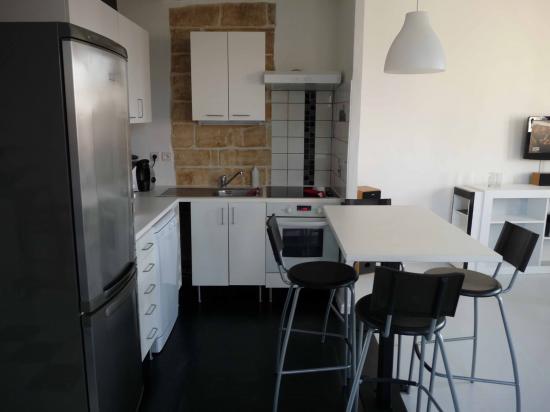 La cuisine en open space avec une table unique, pied fabriqué sur mesure en fer forgé