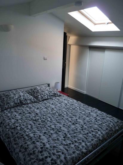 La chambre avec son grand placard  à gauche équipé d'étagères et penderies